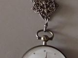 a clock hanging on the wall with a chain attached to it