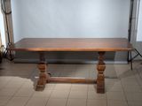une grande table en bois qui se trouve au milieu d'une pièce
