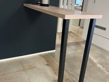 une table surmontée d'une étagère, au milieu d'une pièce