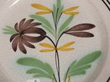a plate with a flower design on it sitting on a table