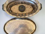 two silver trays sitting on top of each other on a table