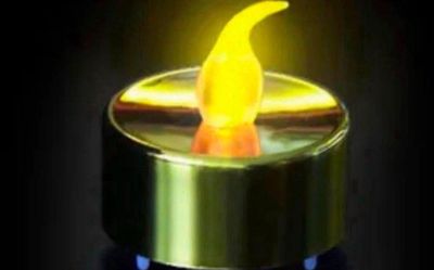 une bougie jaune allumée dans l'obscurité