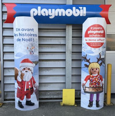 deux bannières de Noël accrochées sur la façade d'un immeuble