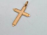 a close up of a gold cross on a white surface