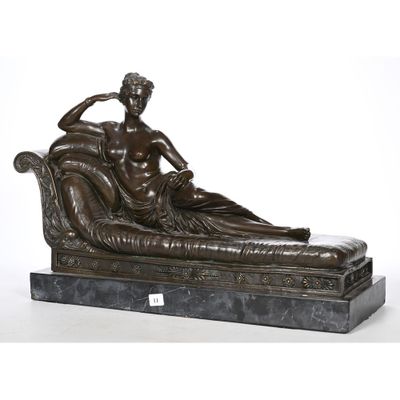 a bronze statue of a man sitting on a couch