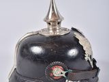 pair of antique german military helmets with silver decorations on them