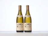 two bottles of white wine sitting on top of a table