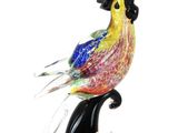 un oiseau en verre coloré perché sur le dos d'un chat noir