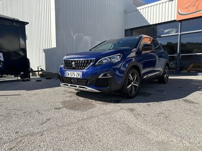 a blue car parked in front of a building next to a trailer