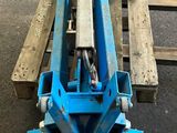 une machine bleue posée sur une palette en bois