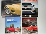 quatre livres posés sur une table blanche, avec un camion rouge en arrière-plan