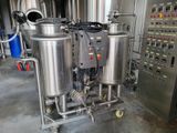 stainless steel tanks are lined up in a factory with a lot of equipment