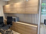 a desk with two chairs and a cabinet in the room