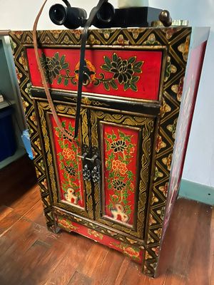 a red and gold cabinet with a black handle on it
