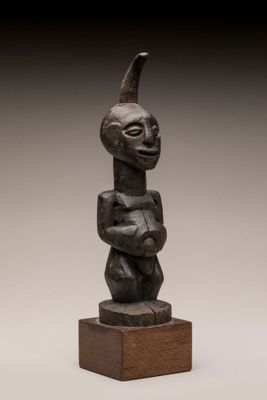 une sculpture en bois représentant un homme coiffé d'un chapeau