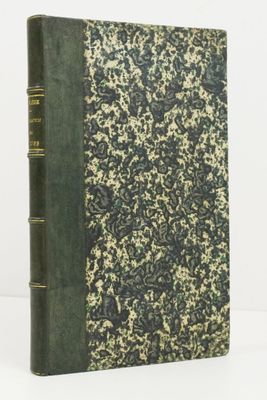 un livre à la couverture verte posé sur une table blanche