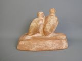 une statue représentant trois oiseaux perchés sur un morceau de bois