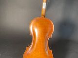 an old violin with a wooden back and bow on a black background