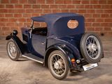 a blue car parked in front of a brick wall
