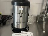 a silver and black juicer sitting on top of a metal counter