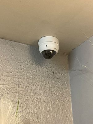 une caméra blanche fixée au mur d'une pièce