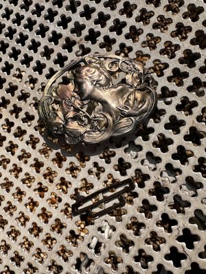 un objet argenté posé sur une grille métallique au sol