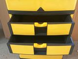 a yellow and black chest of drawers sitting on the floor