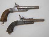 two old guns are on a white surface with a white background