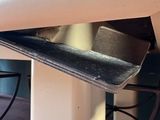 a metal shelf that is underneath a table in a room