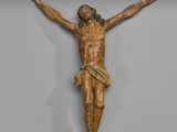 un gros plan d'une statue de Jésus sur une croix, accrochée à un mur