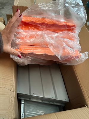 a woman holding a box full of carrots in it