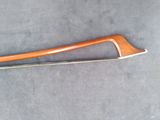a close up of a wooden bow on a gray surface