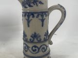 an old blue and white pitcher with a bird on it