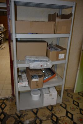 une étagère sur laquelle sont posées de nombreuses boîtes, dans une pièce