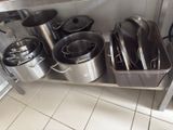 many pots and pans sitting on a shelf in the kitchen