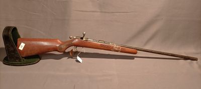 un vieux fusil avec un canon en bois et un étui en cuir