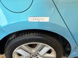 a small blue car with a sticker on the side of it