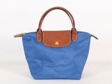 un sac à main bleu et marron posé sur une surface blanche
