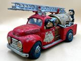 un camion de pompiers miniature avec un tonneau à l'arrière