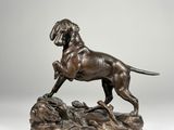 a bronze statue of a dog standing on top of a rock