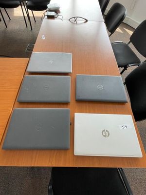 quatre ordinateurs portables posés sur une table dans une salle de réunion