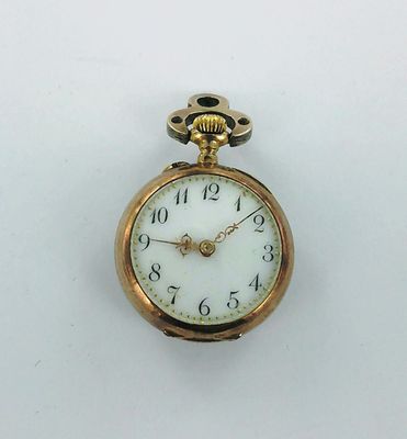 une montre de poche en or avec un cadran blanc sur une surface blanche