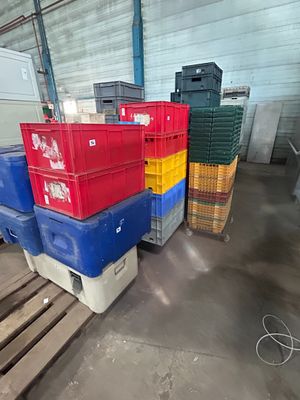 de nombreuses caisses empilées sur des palettes dans un entrepôt