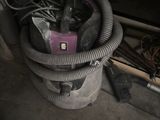 un aspirateur posé par terre à côté d'un tas de fils