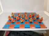 a lot of figurines that are sitting on a chess board