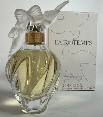 un flacon de parfum orné d'un oiseau, à côté d'une boîte