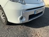une petite voiture blanche garée sur le bord de la route