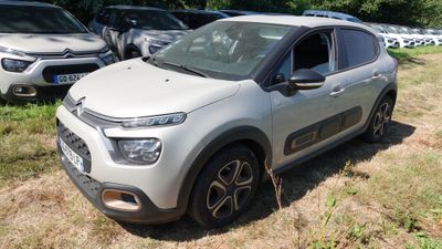 une Citroën argentée garée dans l'herbe à côté d'autres voitures