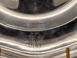an antique silver plate with a gold handle on a stand