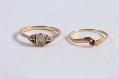 deux bagues en or ornées d'une pierre grise et d'une pierre rouge